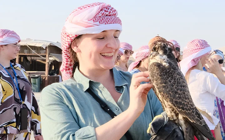 Tourist holding falcon at Wild Dunes Desert Safari Qatar