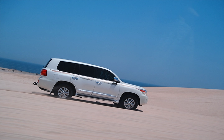 SUV climbing desert dunes during Wild Dunes Desert Safari Qatar